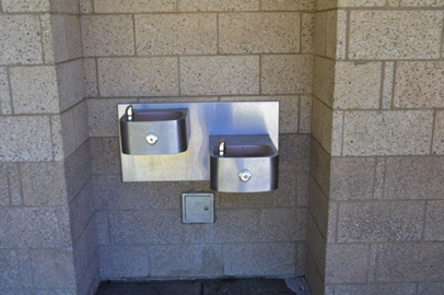 Water fountains on the outside of the restroom at sports field